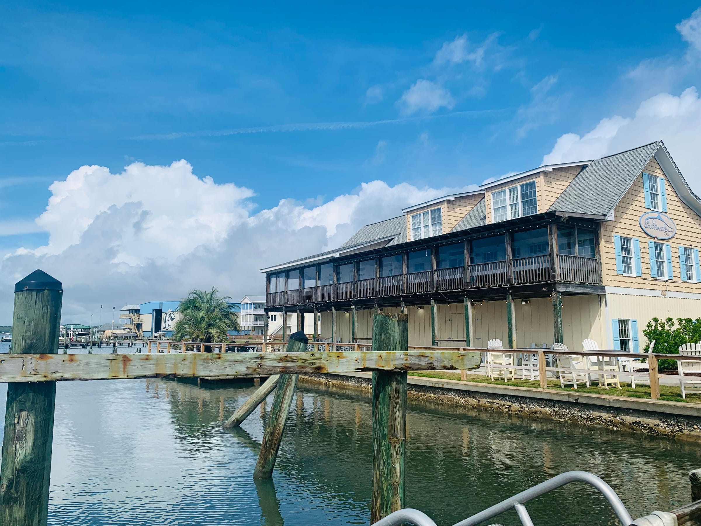 A two-storey waterfront building with a long upper balcony at Swansboro, seen across the water from a dock